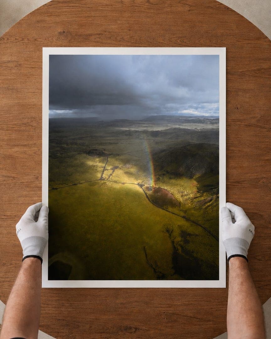 Fine art print held in white gloves on a timber table